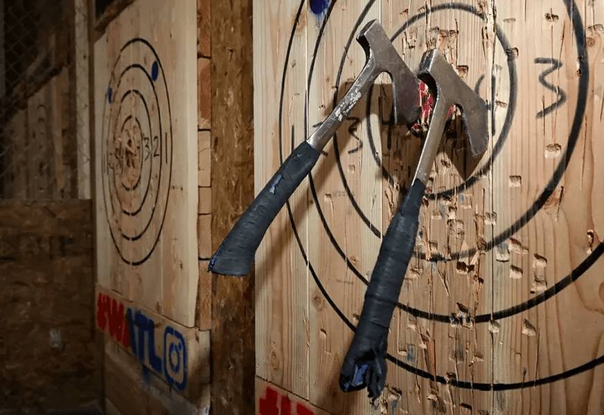 Axes stuck in a target at Midway's axe throwing lanes