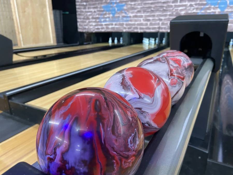 Duckpin balls lined up in the ball return