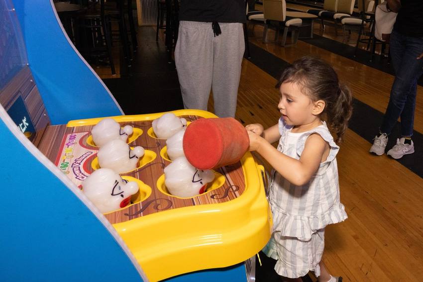 A young girl playing an arcade game